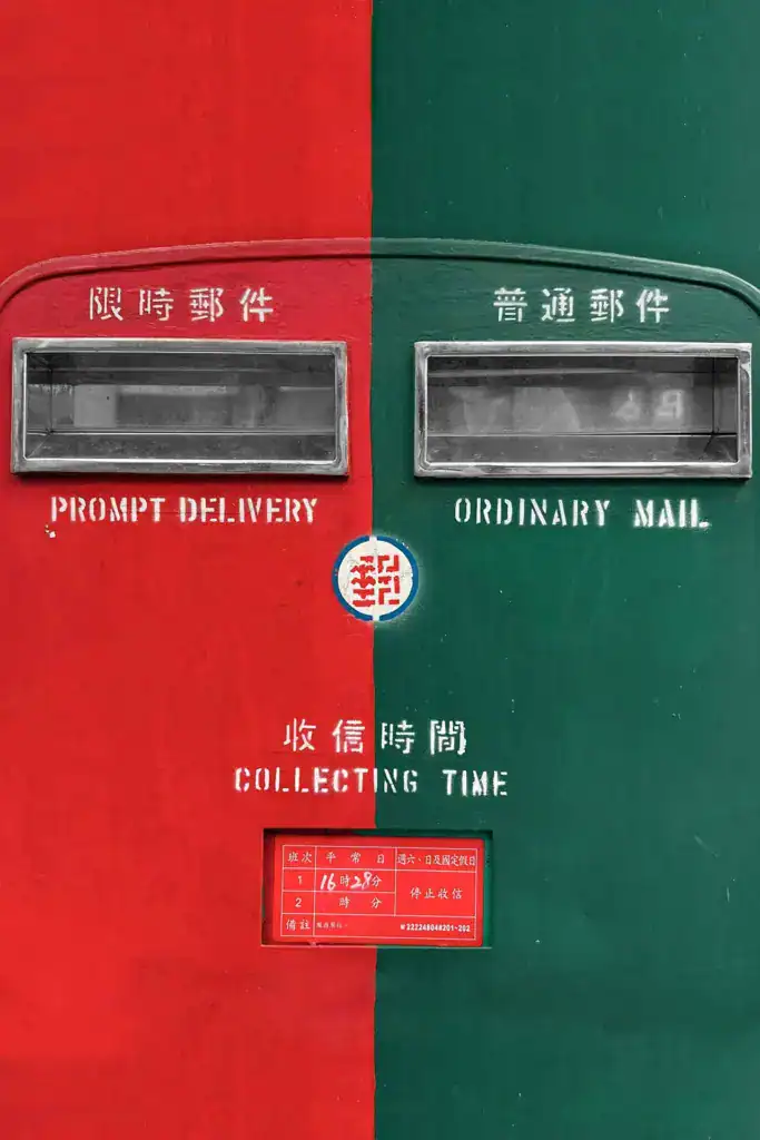 郵筒上標示普通郵件與限時郵件的投遞口，對照明信片寄送時的郵資差異與寄送方式選擇