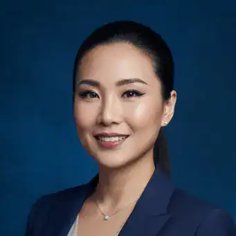 行銷公司女老闆形象照，身穿藍色西裝外套，深藍色背景的專業肖像